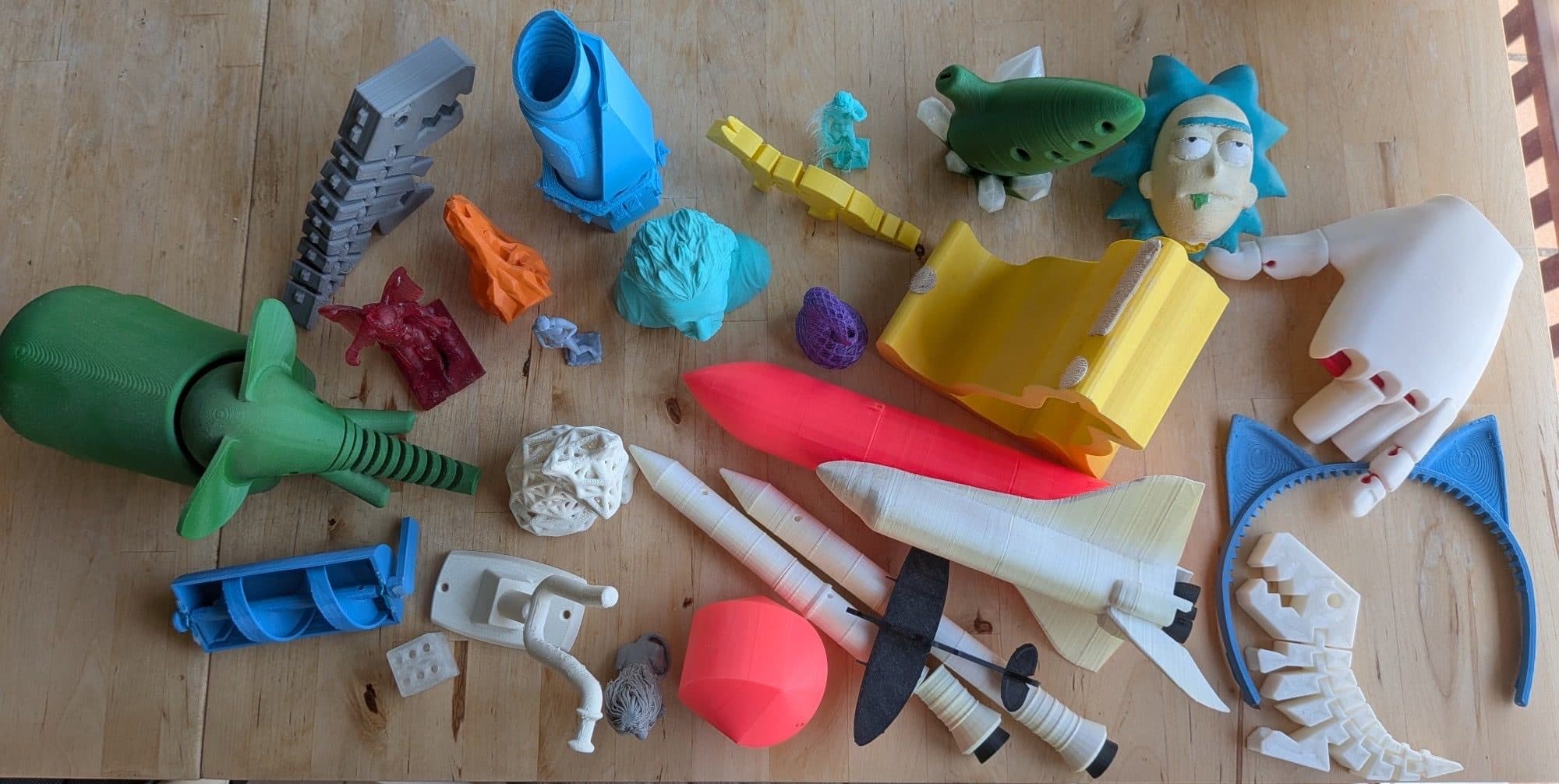 Una taula plena d'impressions 3D: un transbordador espacial, coets, una mà, una ocarina i més